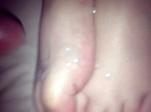 Amateur performs footjob on cock in 69 position, stroking with feet