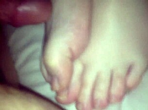 Amateur performs footjob on cock in 69 position, stroking with feet