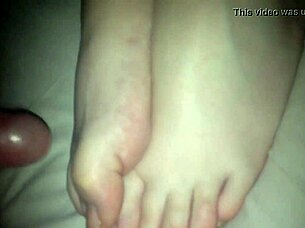 Amateur performs footjob on cock in 69 position, stroking with feet