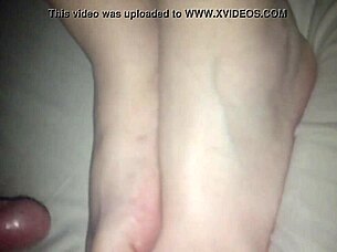 Amateur performs footjob on cock in 69 position, stroking with feet