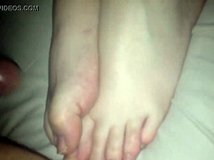 Amateur performs footjob on cock in 69 position, stroking with feet