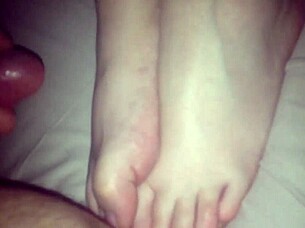 Amateur performs footjob on cock in 69 position, stroking with feet