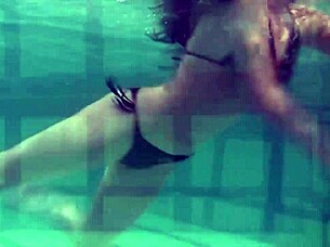 Brunette teen swims naked in pool, tight pussy exposed.