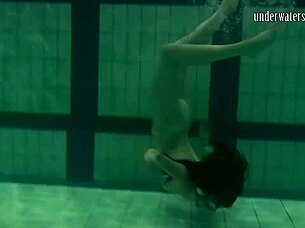 Brunette teen swims naked in pool, tight pussy exposed.