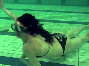 Brunette teen swims naked in pool, tight pussy exposed.