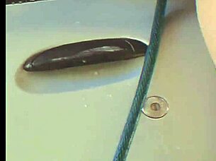 brunette washing car with hose in fun way