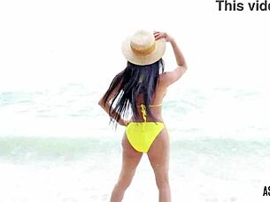 Asiantgirl in yellow bikini masturbates cock outdoors with handjob.