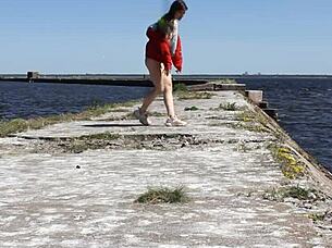 naked woman poses nude on the public dock in outdoor reality setting