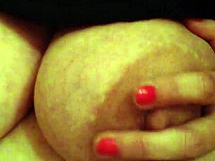 A woman handles her large breasts while working in the office