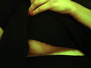 A woman handles her large breasts while working in the office