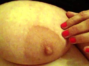 A woman handles her large breasts while working in the office