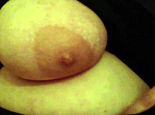 A woman handles her large breasts while working in the office