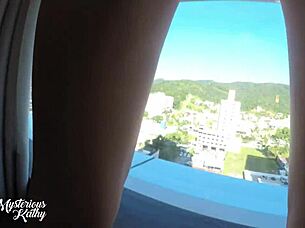 Mysterious Kathy takes cum in hotel window while street watches.