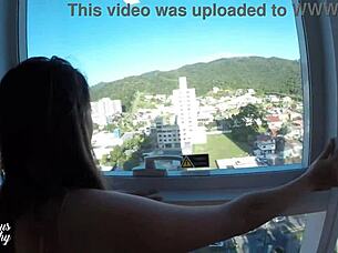 Mysterious Kathy takes cum in hotel window while street watches.