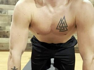 muscular bodybuilder stretching his sexy muscles in the gym