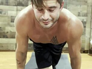 muscular bodybuilder stretching his sexy muscles in the gym