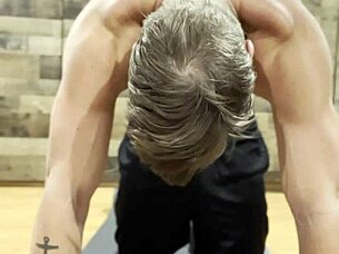 muscular bodybuilder stretching his sexy muscles in the gym